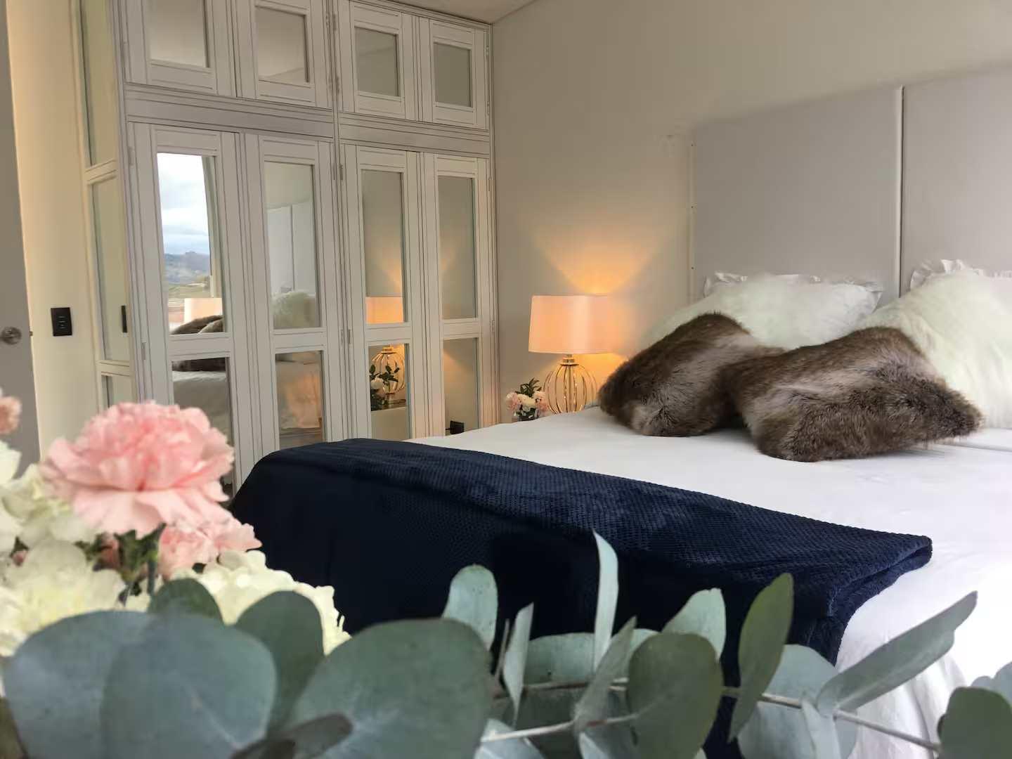 Habitación principal elegante con cama king size y armarios espejo en villa de lujo Peñol