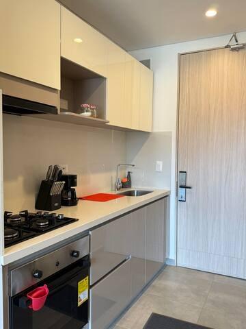 Cocina moderna con acabados en madera y electrodomésticos integrados en apartamento Premium Suite Santa Marta