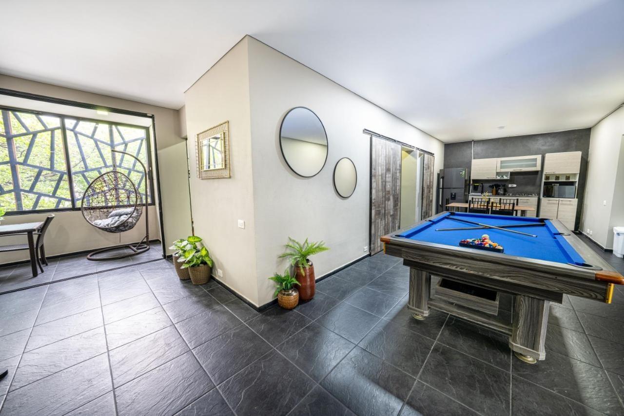 Sala de juegos con mesa de billar azul y columpio colgante en apartamento de lujo en Medellín