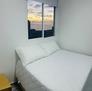 Habitación con cama doble y vista al mar al atardecer en apartamento central de Cartagena