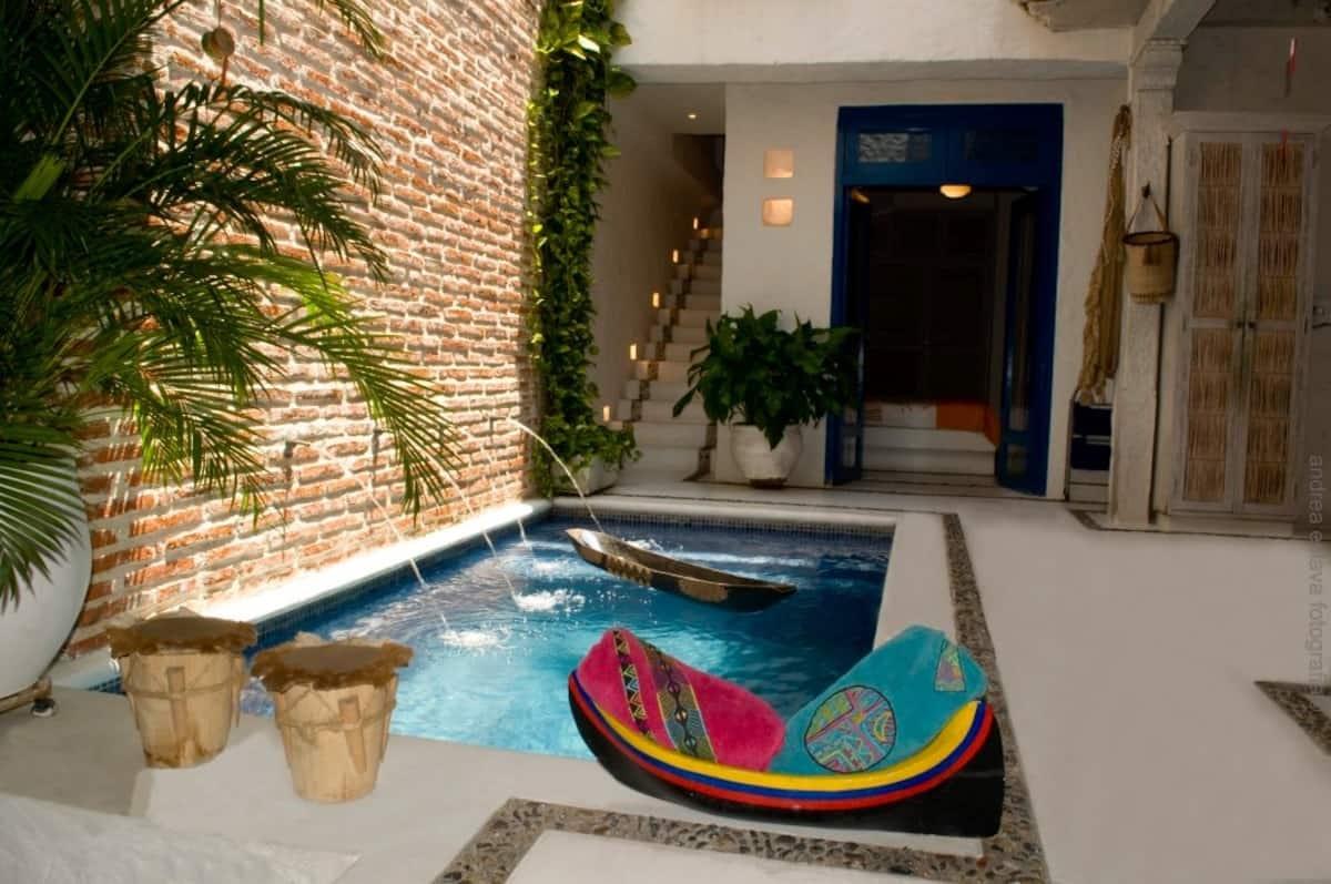 Piscina privada con decoración colonial y plantas tropicales en casa de Cartagena de Indias