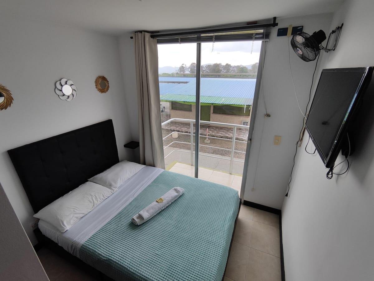 Habitación con cama doble y balcón privado en apartamento vacacional Montenegro cerca Parque del Café