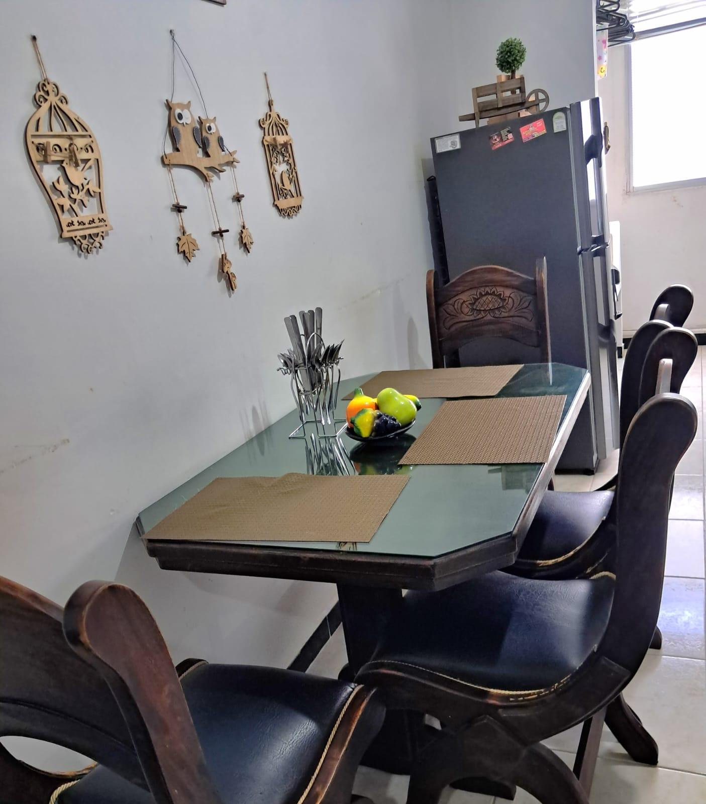 Comedor moderno con mesa de vidrio y sillas negras en apartamento Montenegro