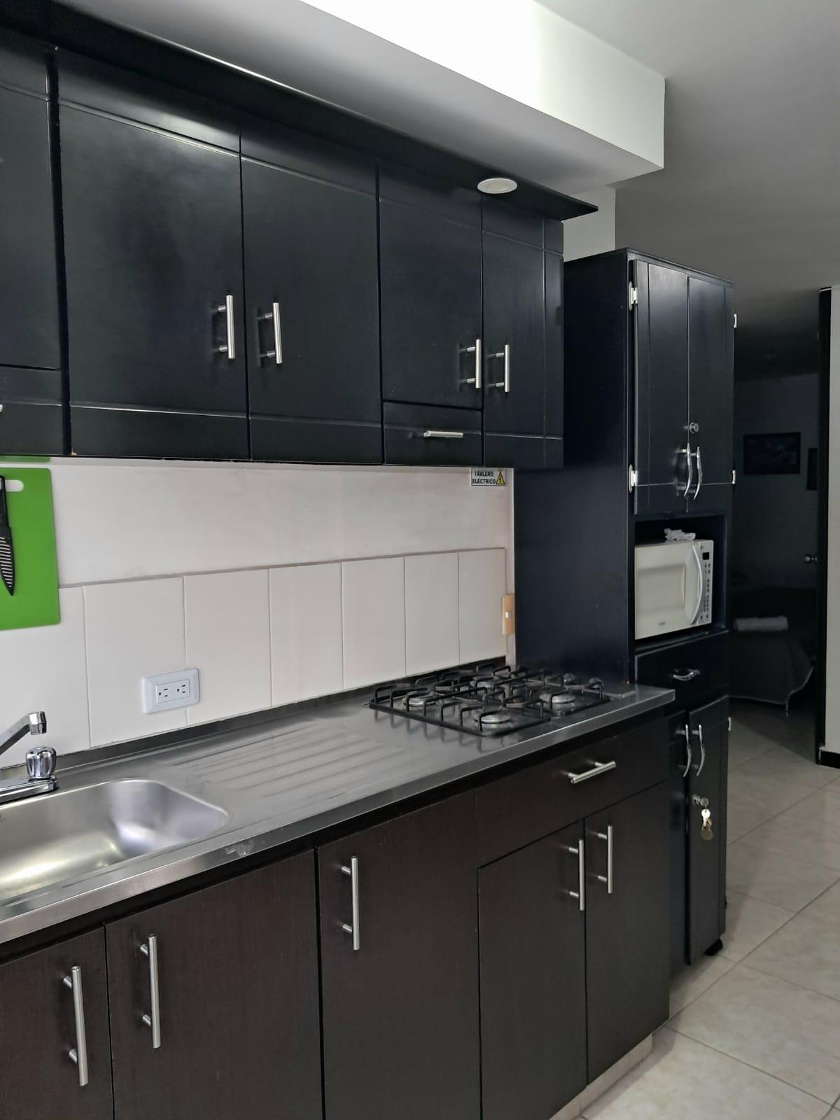 Cocina moderna con gabinetes negros y electrodomesticos en apartamento Montenegro cerca Parque del Cafe